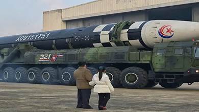 زعيم كوريا الشمالية كيم جونج أون مع ابنته بجوار صاروخ باليستي عابر للقارات في صورة نشرتها وكالة أنباء كوريا الشمالية